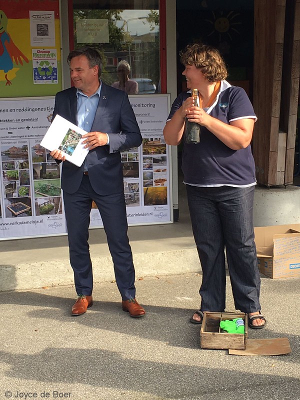 Wethouder Paul Dirkse (Duurzaamheid) en Projectleider Vissenmonitoring Aaf Verkade openen de fles grachtenchampagne